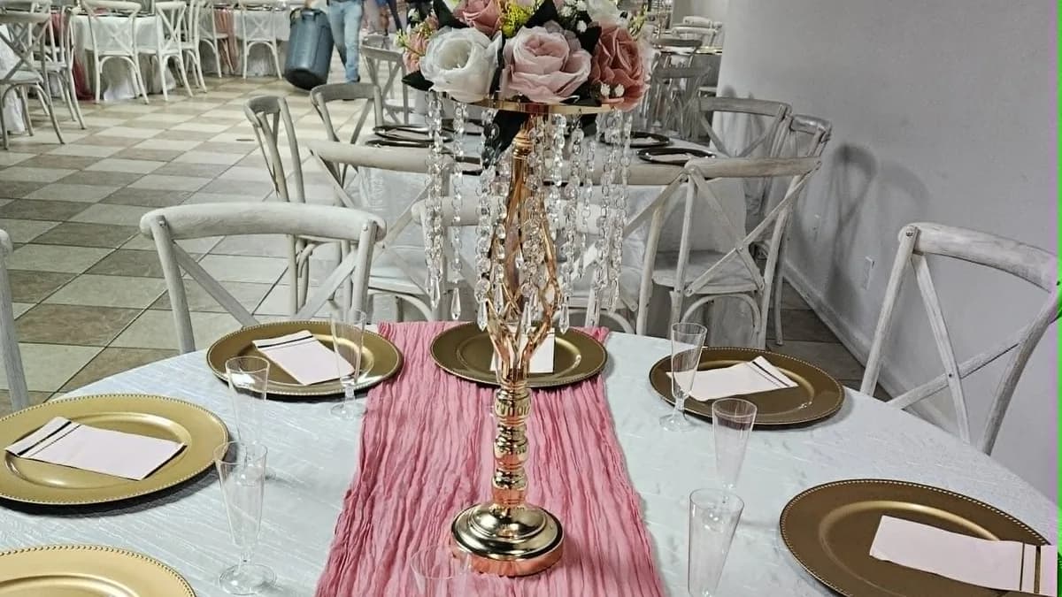 Formal place settings arranged around a pink and gold centerpiece