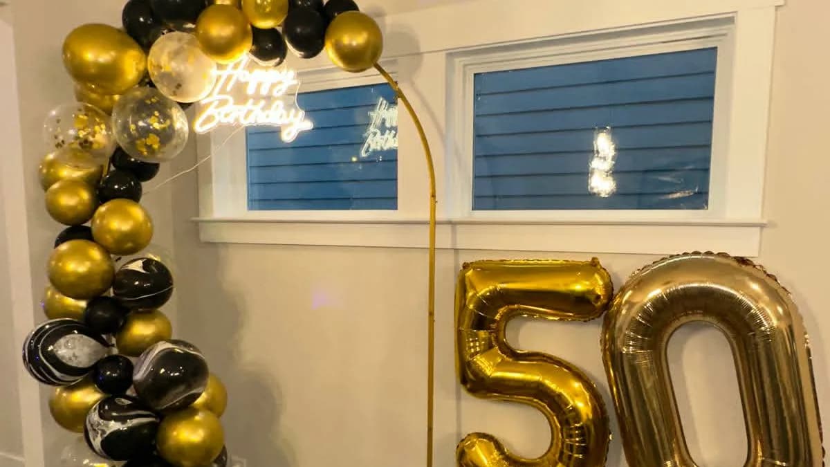 Black and gold balloon arch with a 50th birthday display