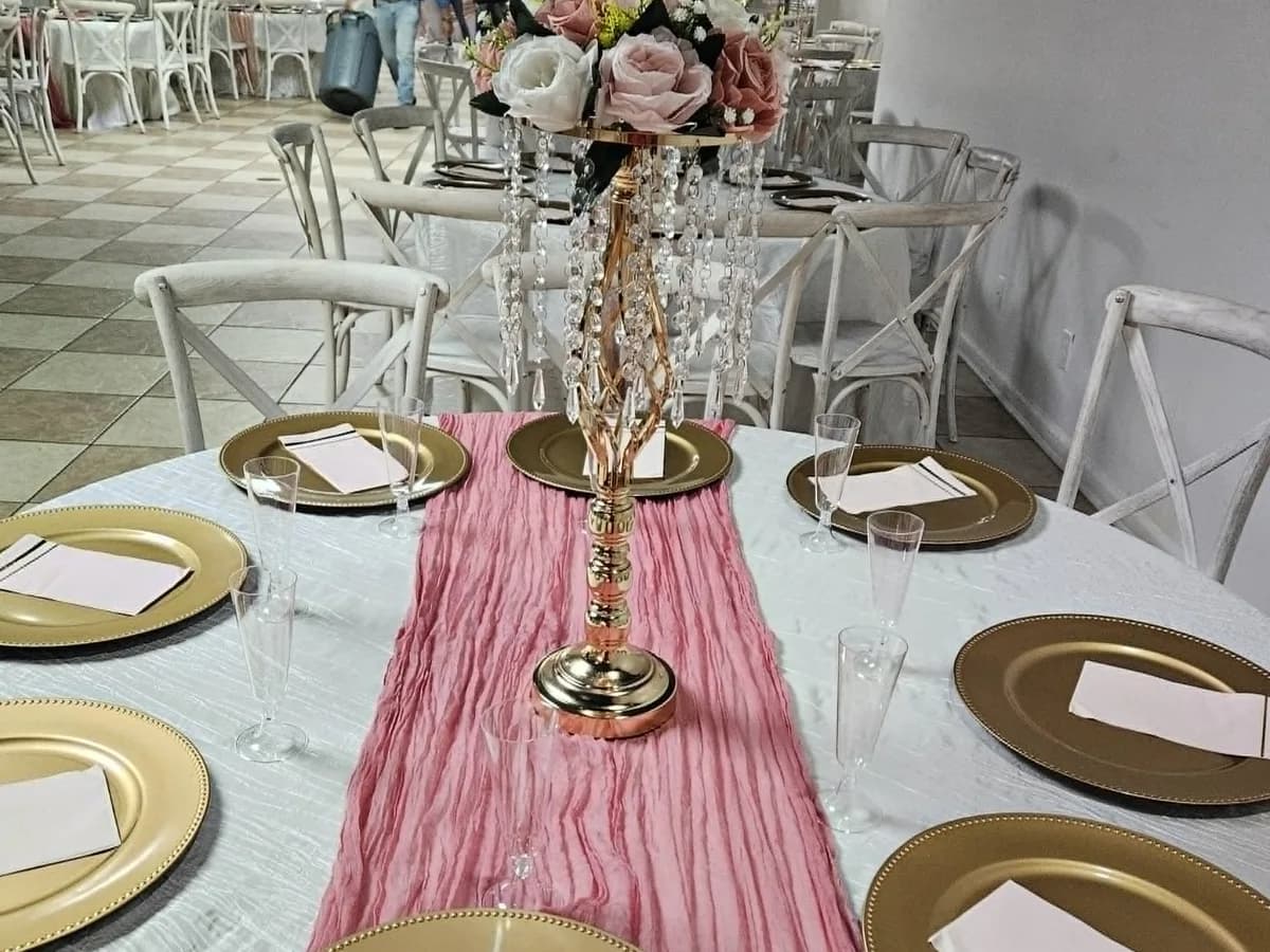 Formal table setting with a pink runner and gold centerpiece