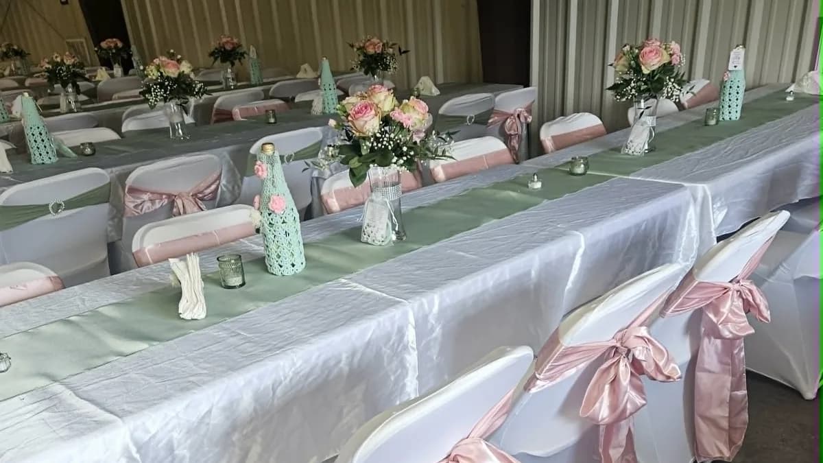 Rows of decorated tables with pink chair sashes and floral centerpieces